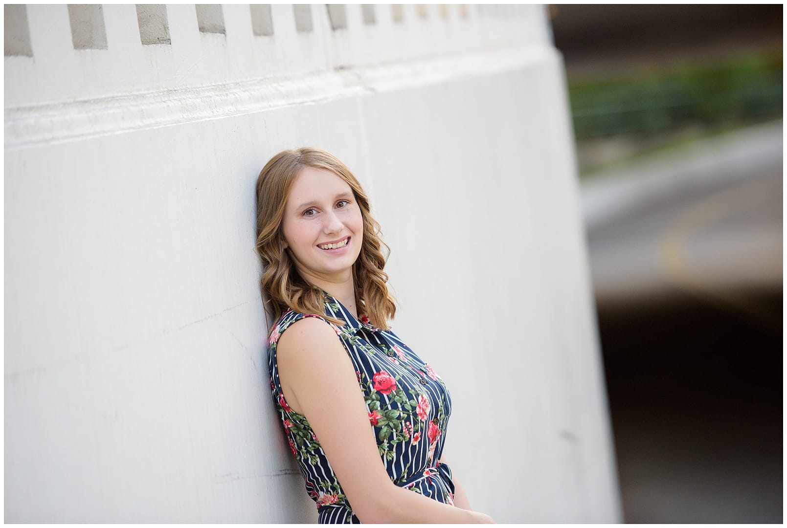 Girl poses against wall for senior portrait. Photos by Tiffany Hix Photography.