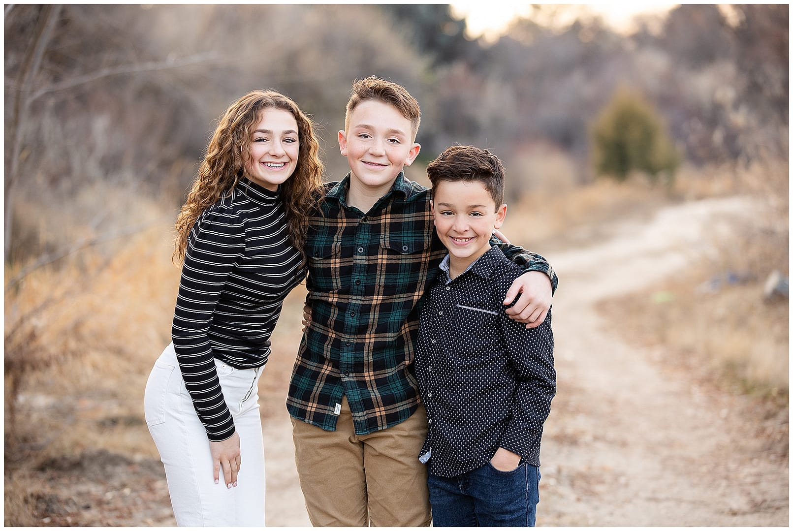 Three siblings in the open space of Boise, ID. Photos by Family Photographer, Tiffany Hix Photography.