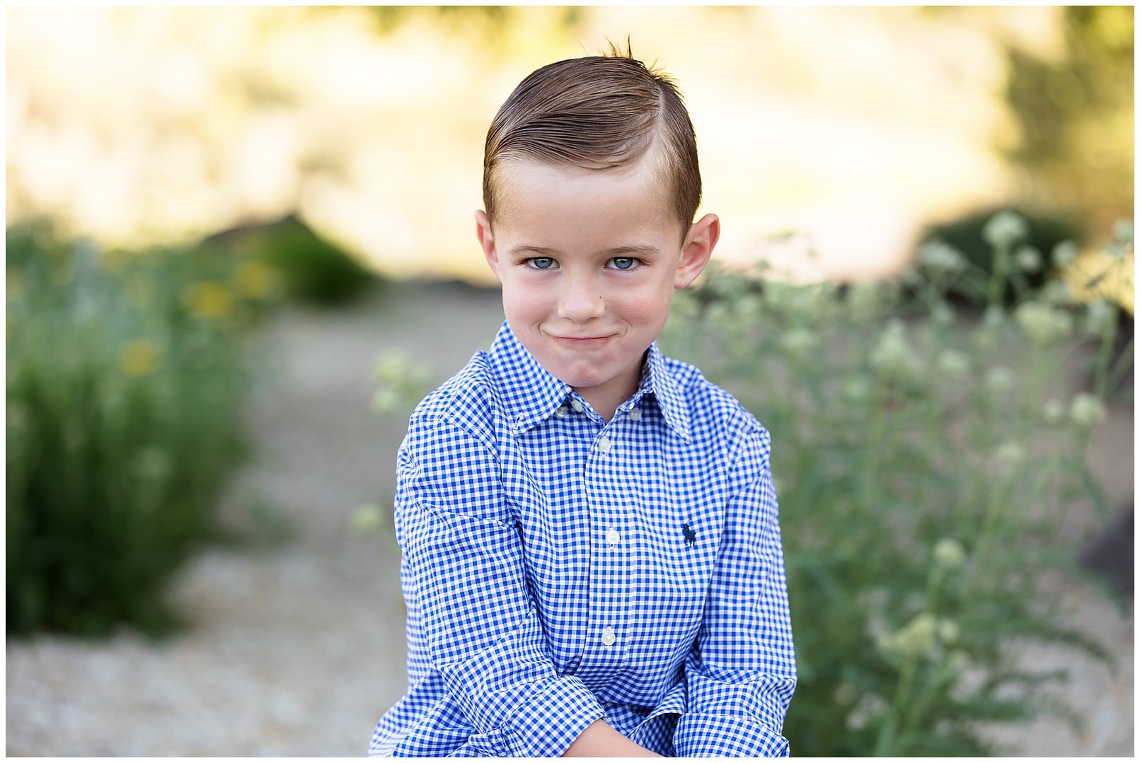 Brown hair blue eyed boy smirks for camera. Photo by Tiffany Hix Photography.