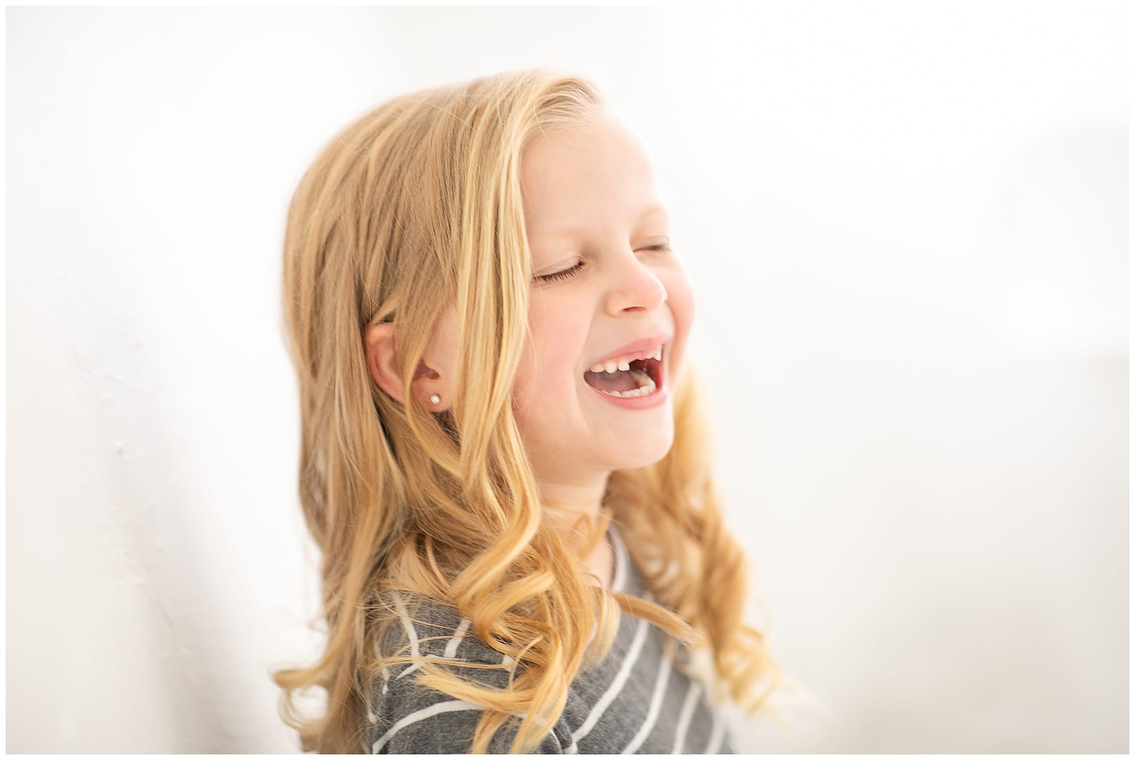 Young girl laughs during photo session. Photos by Tiffany Hix Photography.