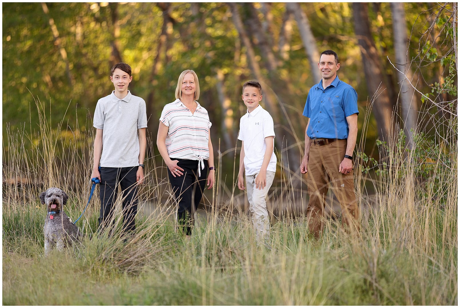 Family of four stands in marsh for photos. Photos by Tiffany Hix Photography.