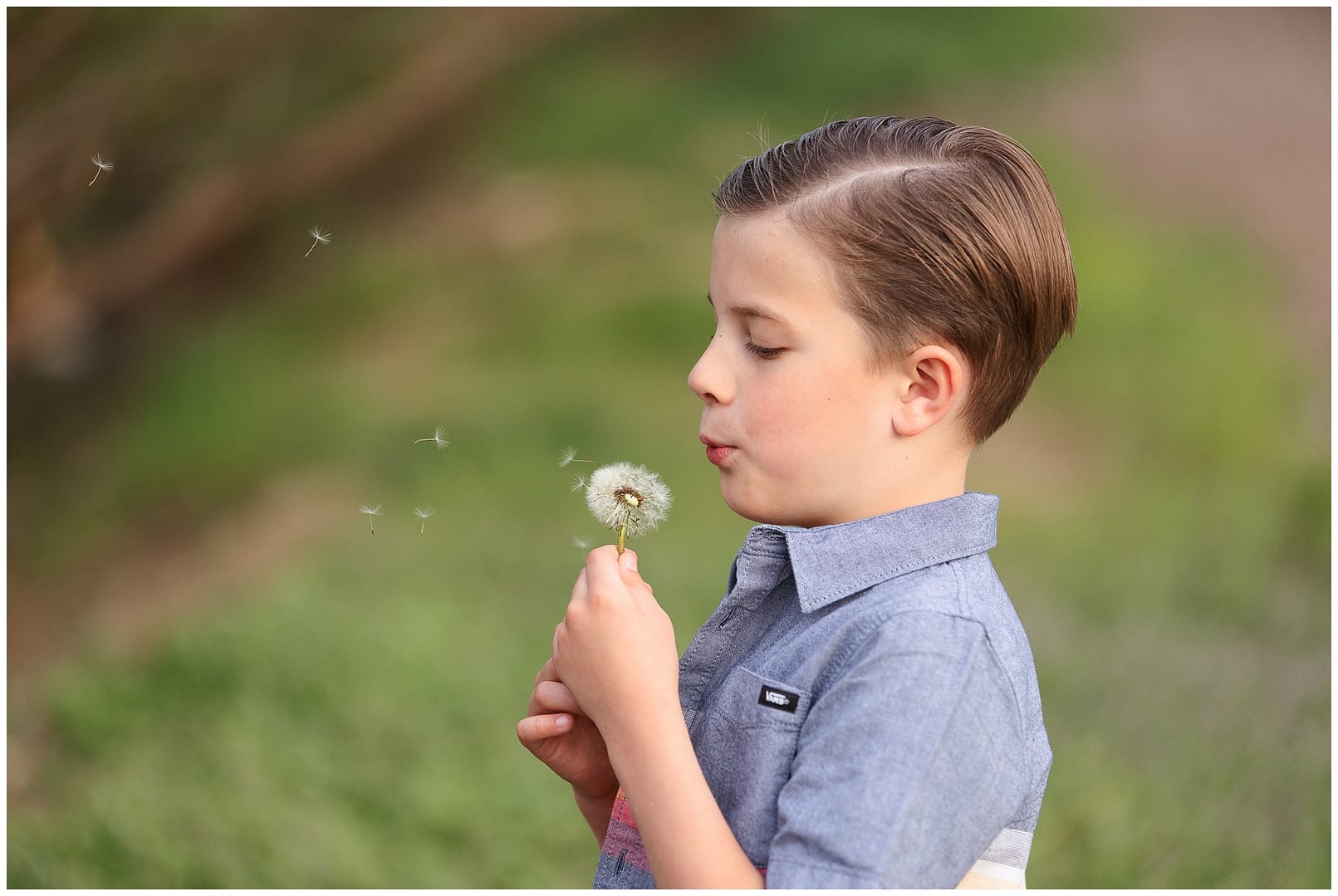 Boy blows wishing flower. Photo by Tiffany Hix Photography.