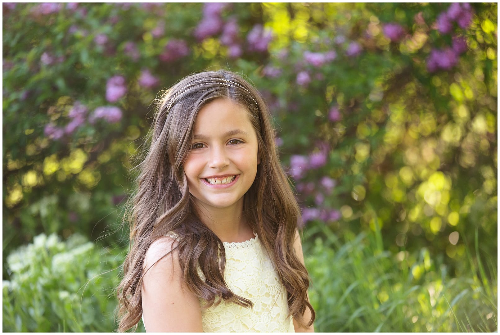 Young girl poses for photograph amongst lilacs. Photos by Tiffany Hix Photography.