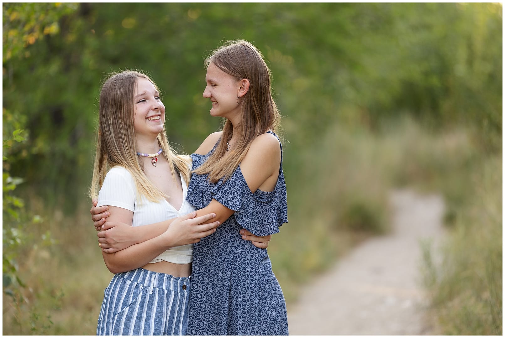 Sister sibilngs laugh with one another during Boise family session. Photo by Tiffany Hix Photography.