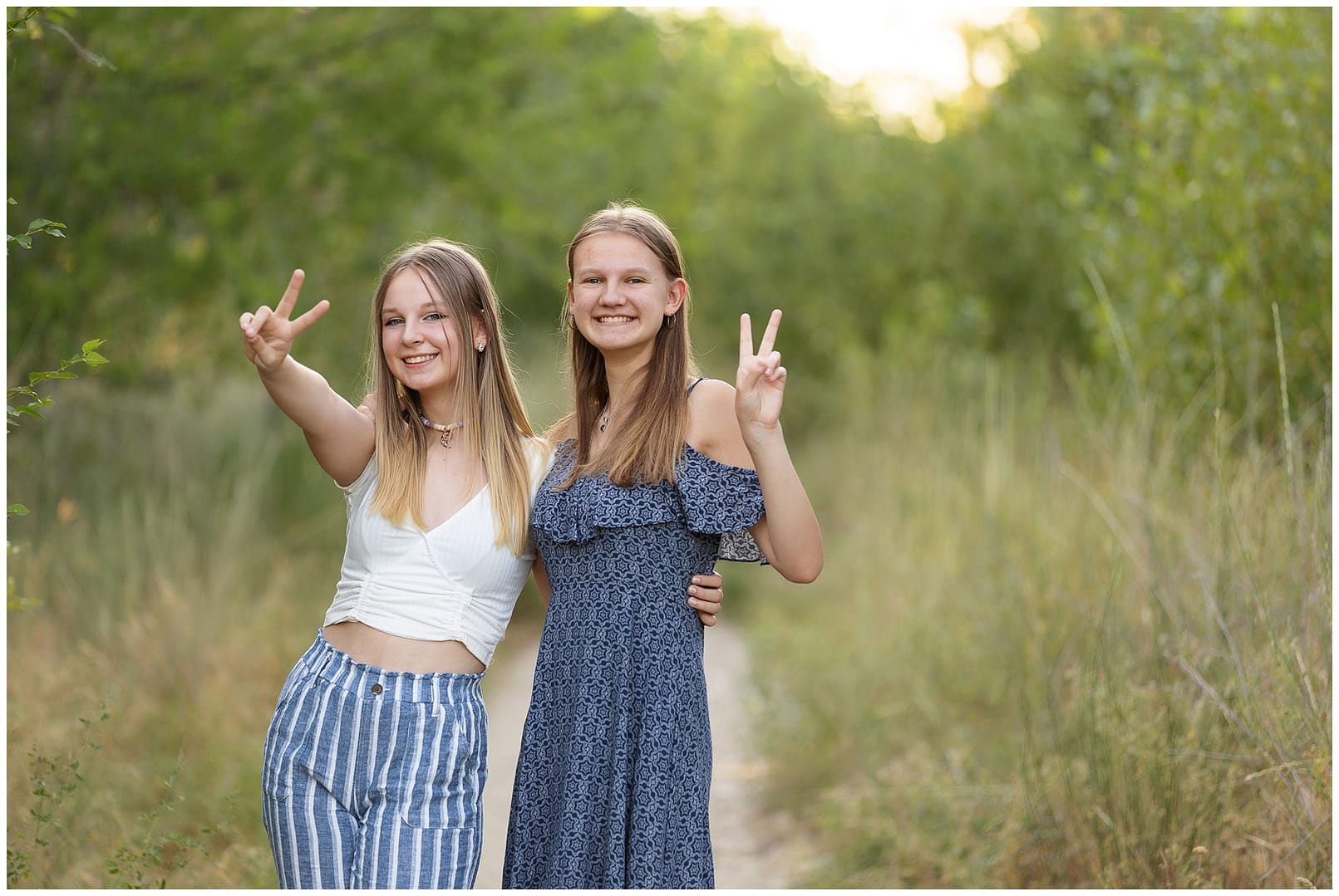 Sisters give peace sign during family session. Photo by Tiffany Hix Photography.