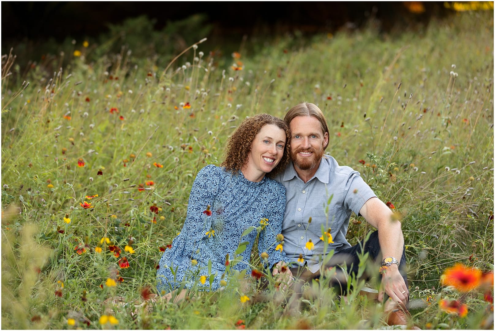 Mom and Dad snuggle in a field of wildflowers. Photo by Tiffany Hix Photography.