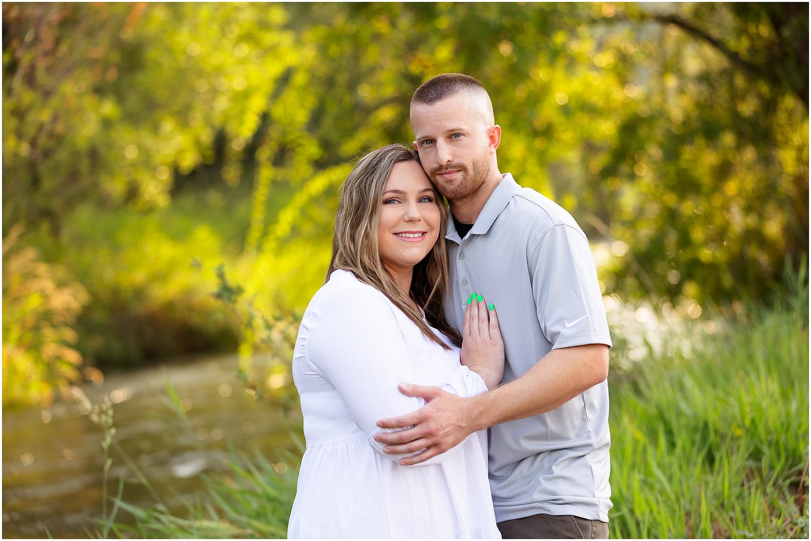 Soon to be parents take portrait by river. Photo by Tiffany Hix Photography.