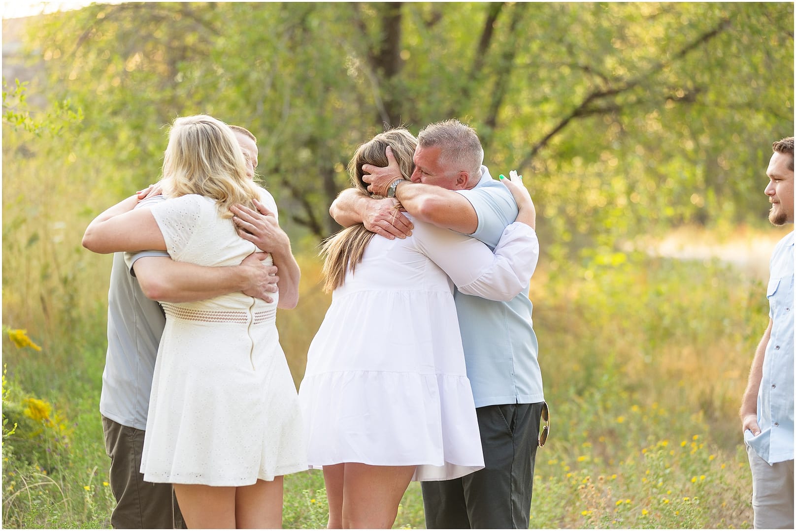 Grandparents to be hug daughter and son in law during Boise pregnancy session. Photo by Tiffany Hix Photography.