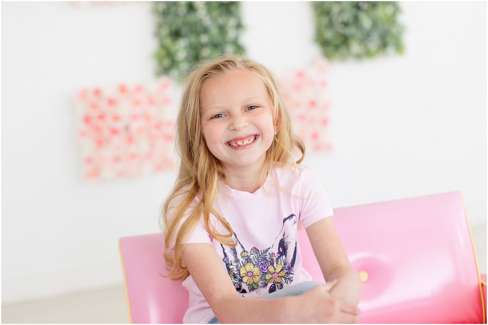 Blonde hair girl smiles in pink shirt. Photo by Tiffany Hix Photography.