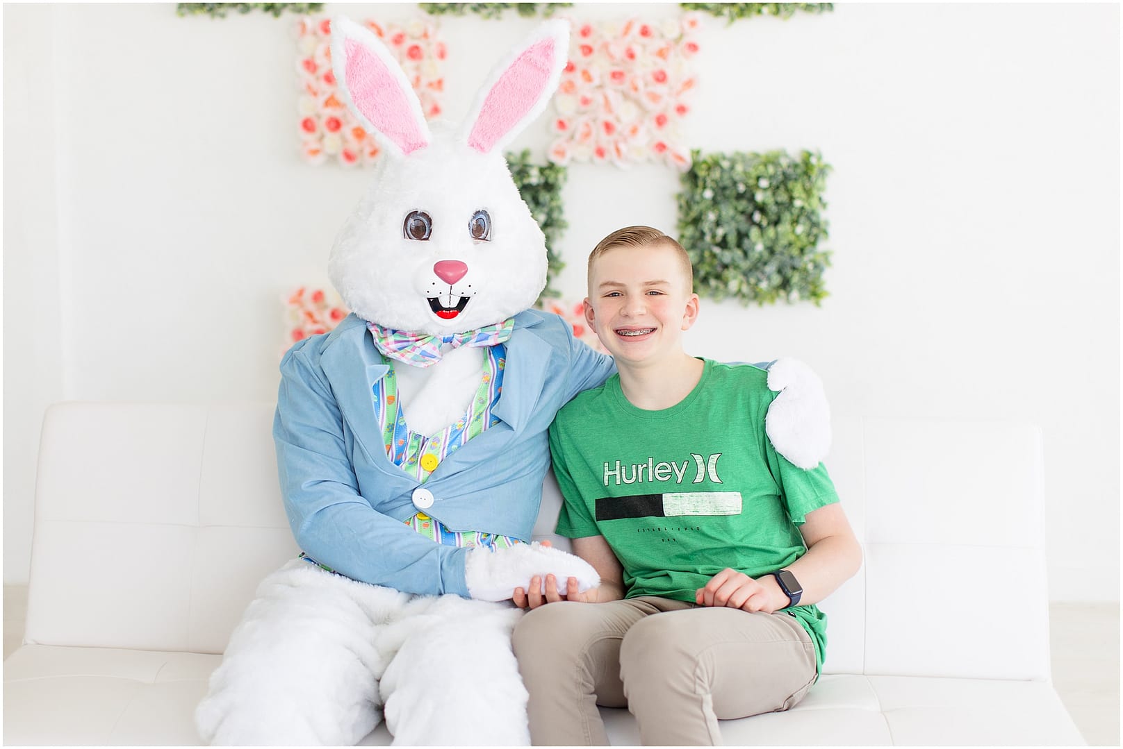 Boy in green shirt smiles next to the Easter Bunny. Photo by Tiffany Hix Photography.