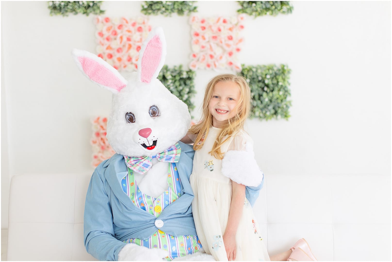 Little girl smiles sitting in the Easter Bunny's lap. Photo by Tiffany Hix Photography.