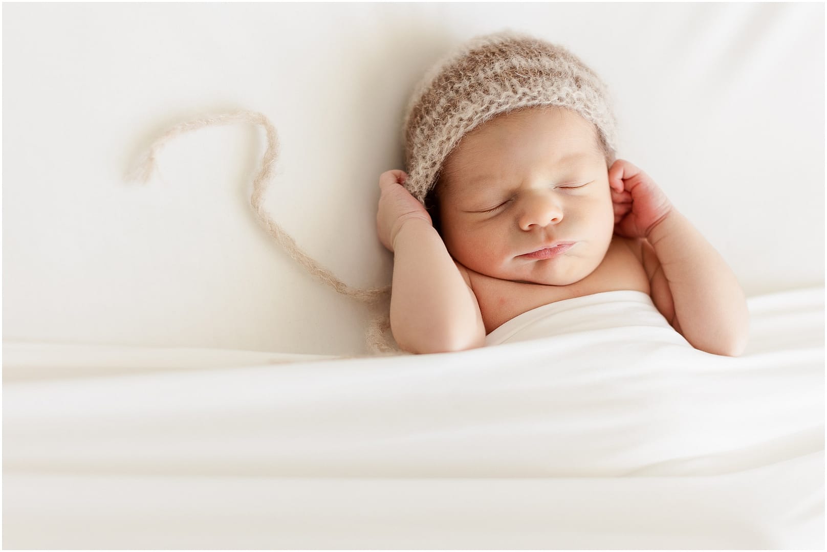 Baby boy in bonnet during Boise newborn studio session. Photo by Tiffany Hix Photography.