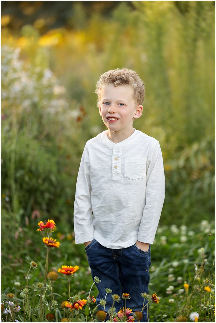 Little boy stands with hands in pockets during Boise family photos. Photo by Tiffany Hix Photography.