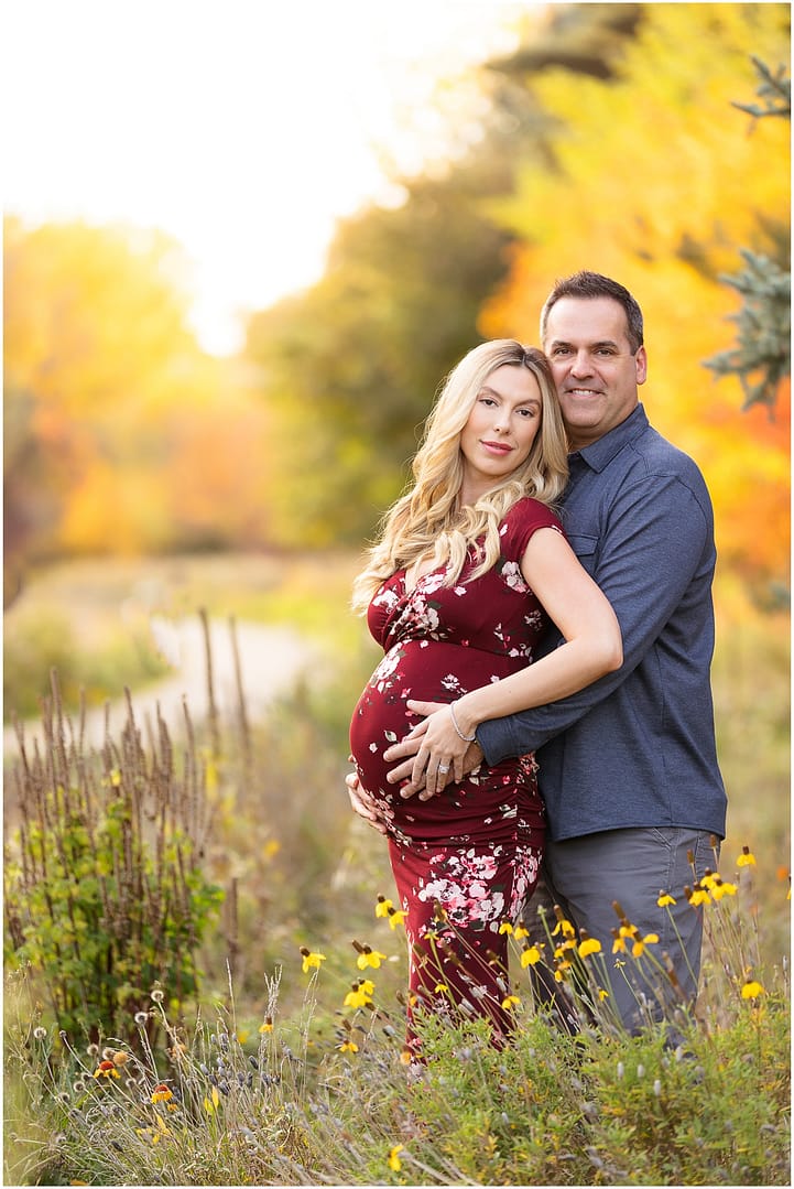 Couple stands among wildflowers during Boise maternity session. Photo by Tiffany Hix Photography.