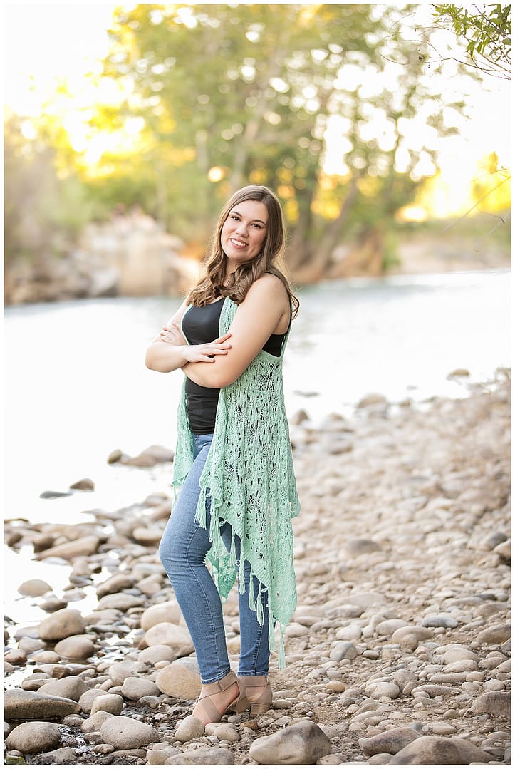 Young woman stands at river for Boise Senior Session portrait. Photos by Tiffany Hix.