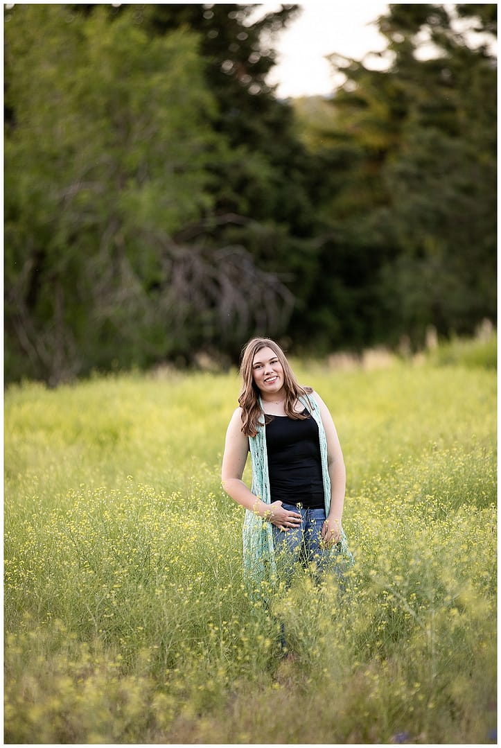 Young woman in field of mustard flowers for her Boise Senior Session. Photos by Tiffany Hix.