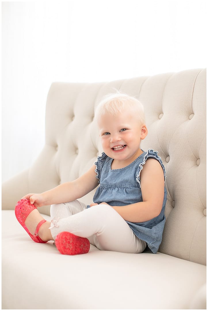 Young girl smiles for portrait in studio. Photos by Tiffany Hix Photography.