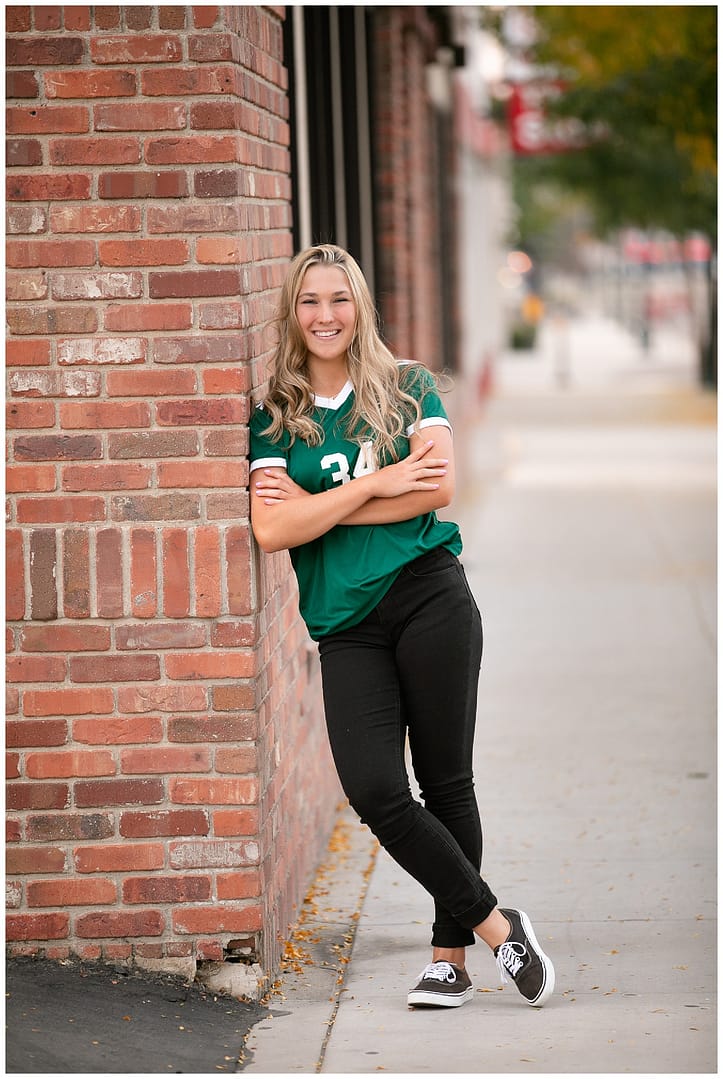 High school senior poses in sports jersey. Photo by Tiffany Hix Photography.