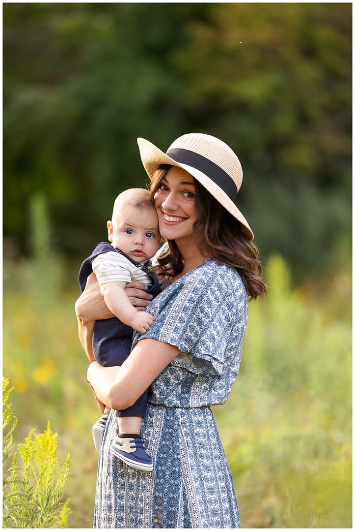 Mom wearing hat holds her 4 month old baby boy. Photo by Tiffany Hix Photography.