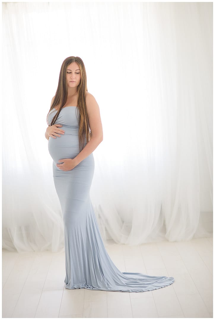 Pregnant mom poses in blue maternity gown. Photos by Tiffany Hix Photography.