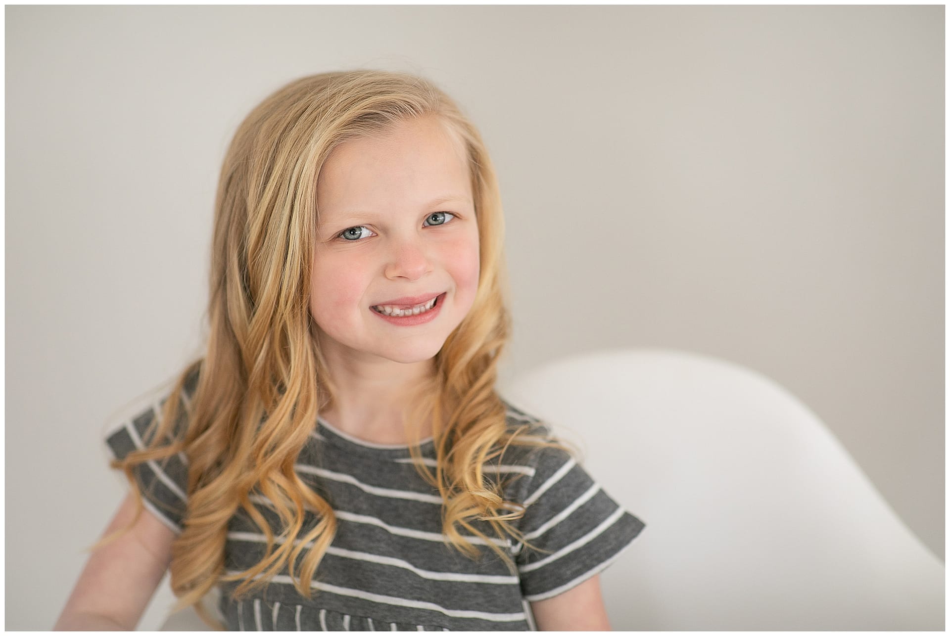 Child smiles for studio session portrait. Photos by Tiffany Hix Photography.