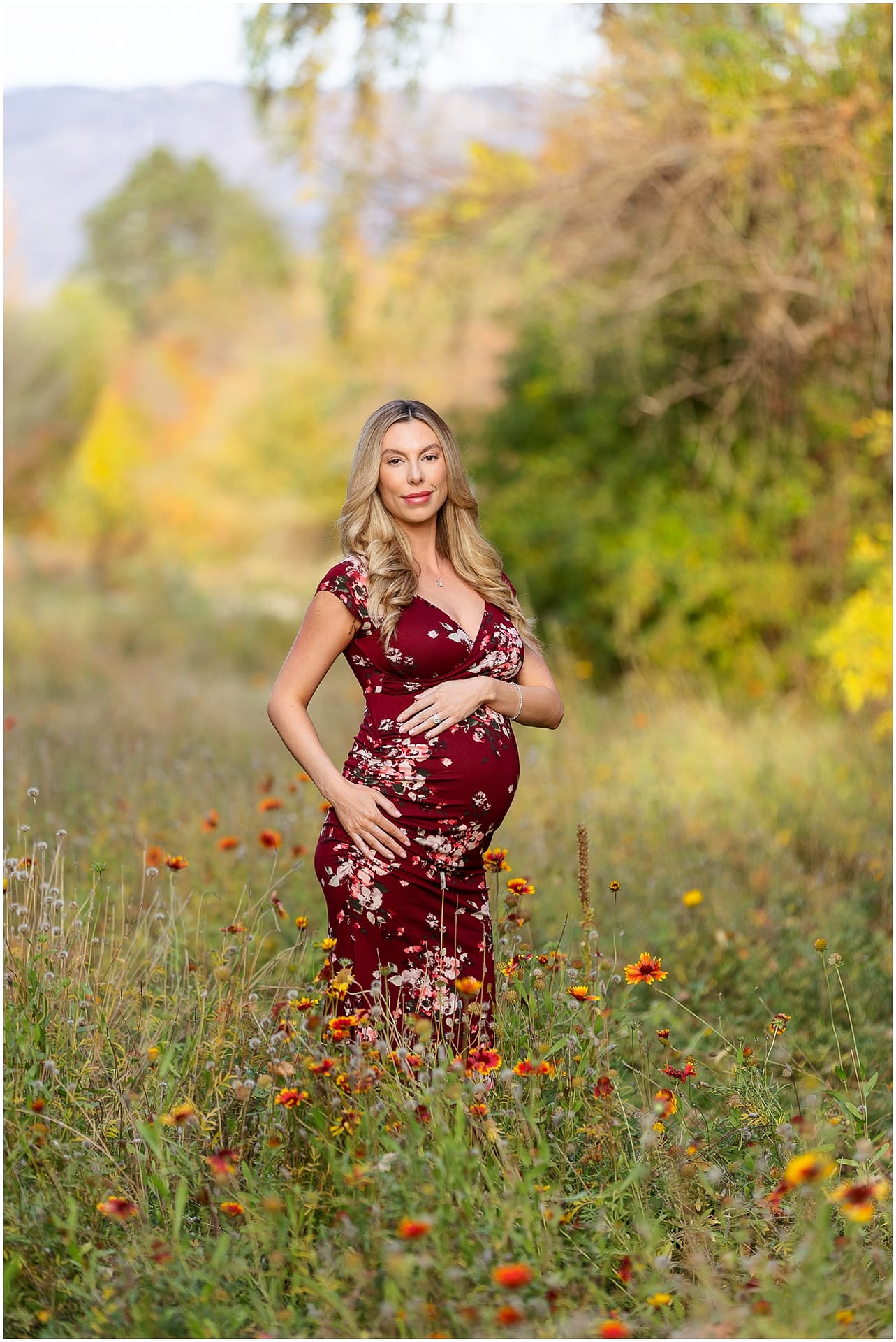 Mom holds her baby bump in field of Boise wildflowers. Photo by Tiffany Hix Photography.