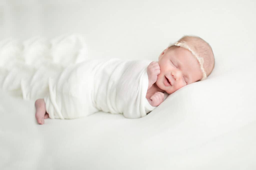 Newborn baby smiling during newborn photography sessions with Boise photographer Tiffany Hix
