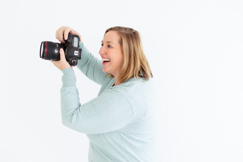Boise family photography Tiffany Hix holding her camera and looking at her clients smiling